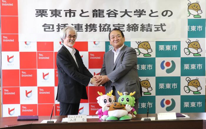 協定締結後、握手する入澤龍谷大学学長と野村栗東市長