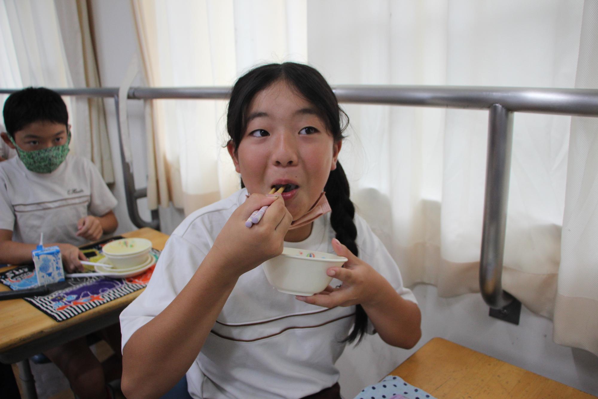 おいしいよと給食を食べるようす