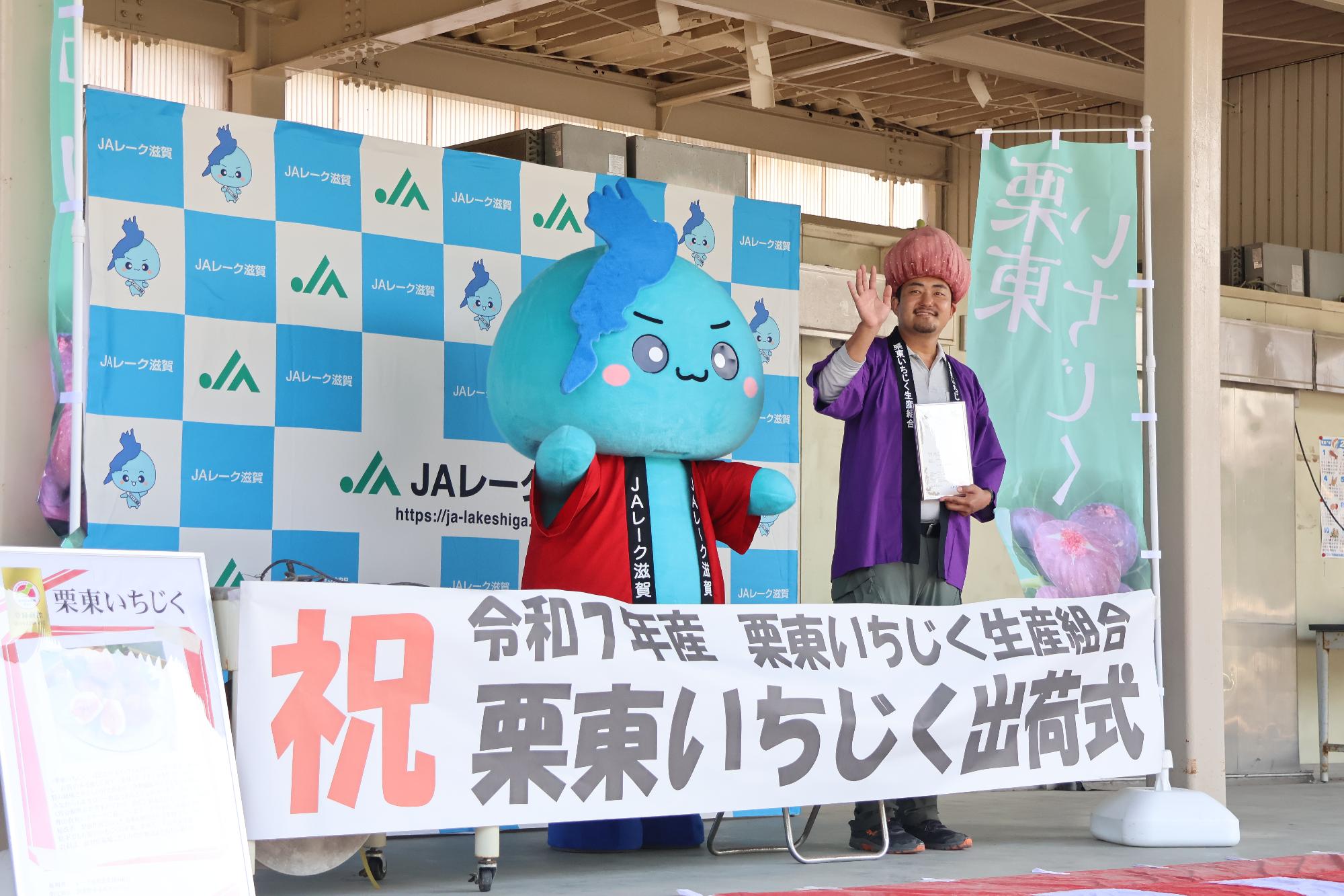 中井さんとびわたんが手を振って見送る様子
